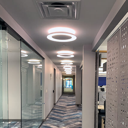 A view of an empty hallway with bright circular overhead lights.