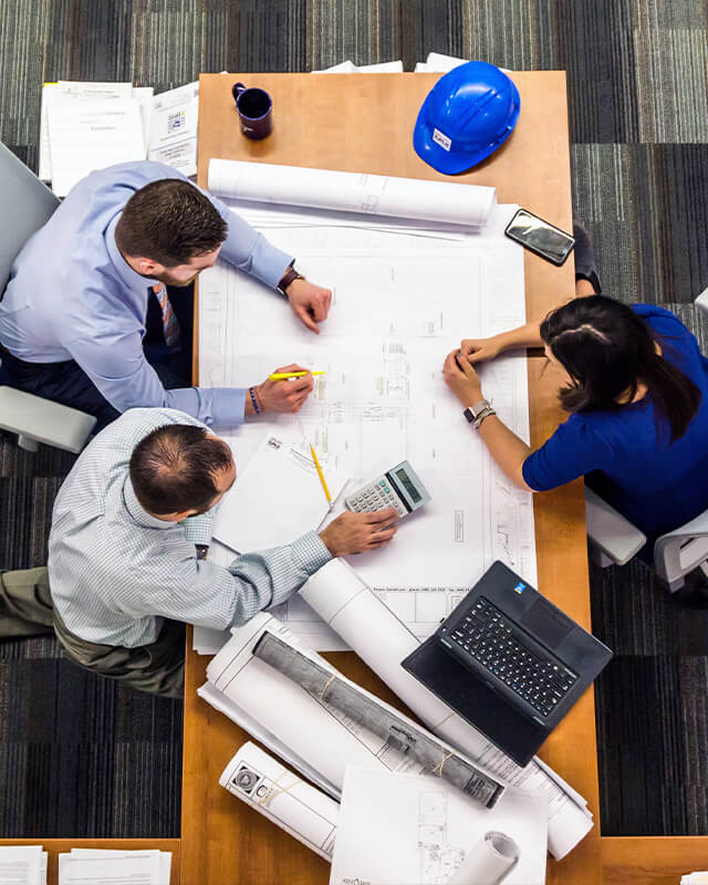 Fran Sinopoli sitting at a desk, reviewing engineering diagrams.
