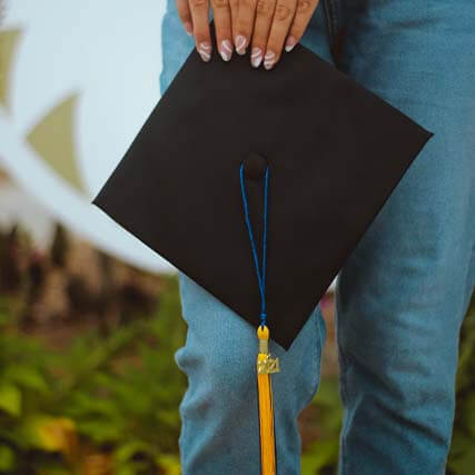 A person holding a graduation hat.